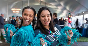 Alumni at Homecoming TEALgate with pom poms