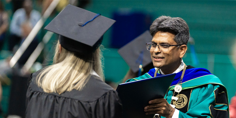Chancellor handing diploma to graduating student
