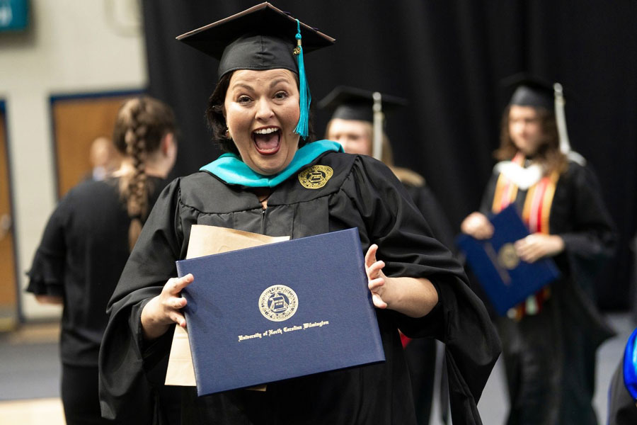 Graduate smiling holding diploma