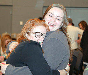 Alumnae hugging each other at event
