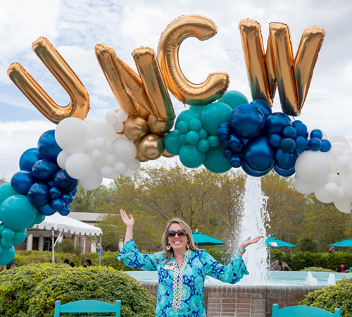 Allison Baringer on campus with UNCW balloon archway