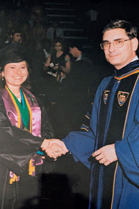 Nicolette Fulton shaking a professors hand at Graduation