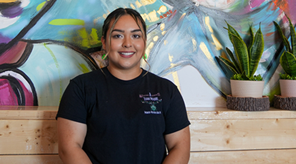 Jahaira A. Romas in front of mural at A Toda Madre