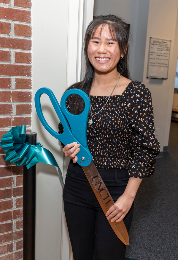 Brienna Rafferty holding scissors at Asian Heritage Cultural Center ribbon cutting