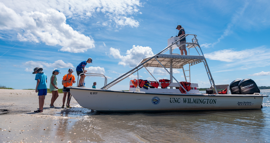 A group of children boarding a UNCW research boat