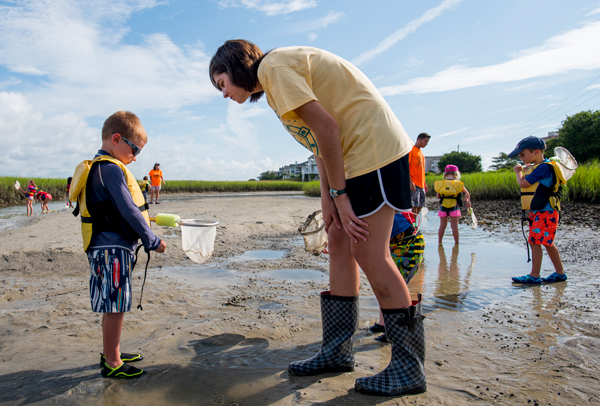 child holding net during shoreline exploration