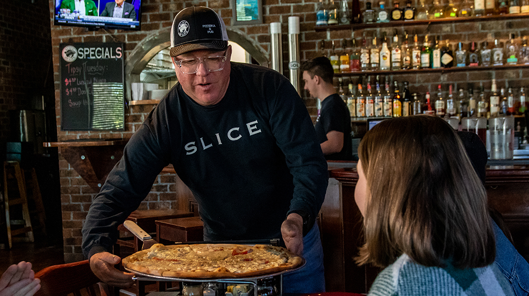 Ray Worrell '93 serving pizza in his restaurant
