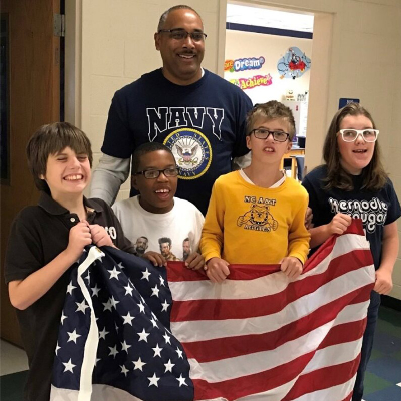 Vernon Johnson '91 holding a flag with his students