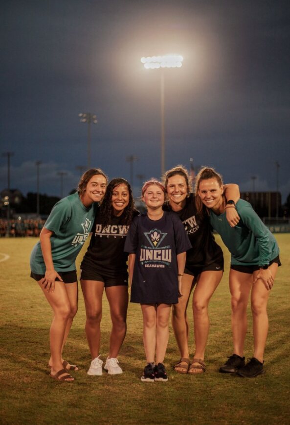 Jennifer Ludemann standing with her teammates in a soccer field.