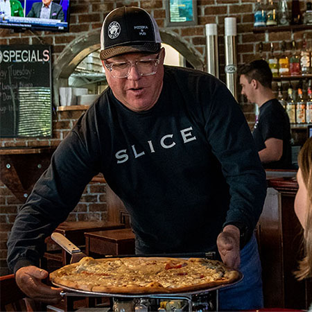 Ray Worrell '93 serving pizza at Slice of Life